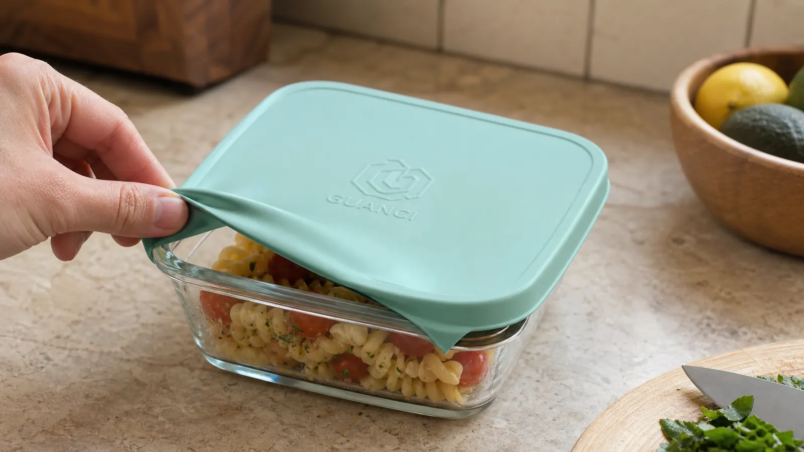 A silicone lid stretched over the corner of a square glass storage container with a visible gap where it doesn't seal